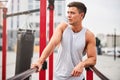 Young muscular man exercising on sports ground outdoors Royalty Free Stock Photo