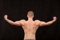 Athletic handsome sportsman fitness-model showing his muscular back. isolated on black background with copyspace Royalty Free Stock Photo