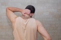 Athletic handsome young man holding his neck from the back. Concept neck pain, posture, muscle sprain, problems, migraine, Royalty Free Stock Photo