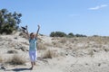 Young happy traveler woman running on the sand dunes coast of Mediterranean sea, beach Beauduc in French Riviera, France