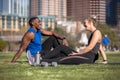 Athletic and healthy fitness partners, friends, male and female exercise group casual in the city park lawn, relaxing and laughing Royalty Free Stock Photo