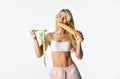 Athletic hungry woman on white. girl in sportswear with tape measure on fork. bread against diet. fit girl with