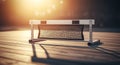 Athletic hurdle with black net on wooden floor, bathed in warm sunlight Royalty Free Stock Photo
