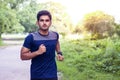 Young athlete man running in sports ground on road in sports wear Royalty Free Stock Photo