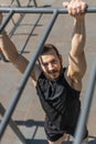 Athletic lebanese man in sportswear doing pull ups exercises on horizontal bar, pumping up back Royalty Free Stock Photo