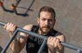 Athletic lebanese man in sportswear doing pull ups exercises on horizontal bar, pumping up back Royalty Free Stock Photo