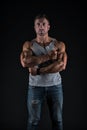 Athletic man cross strong muscular arms with biceps triceps muscles in casual wear black background, sportsman Royalty Free Stock Photo