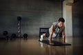 Athletic man doing pushups exercise at dark gym. Royalty Free Stock Photo