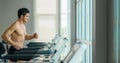 Athletic man doing running exercise on treadmill in gym and fitness center