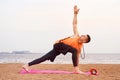 Athletic man doing yoga asanas in nature, sand sea Royalty Free Stock Photo