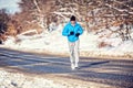 Athletic man jogging and training outdoor in park with snow Royalty Free Stock Photo