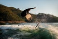 athletic man jump with foil wakeboard over splashing wave Royalty Free Stock Photo