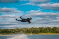 Athletic man practicing wakeboard tricks in training wake park on summer day Royalty Free Stock Photo