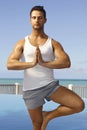 Athletic man practicing yoga outdoors