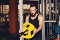 Athletic man puts on plate for barbell in the gym Royalty Free Stock Photo