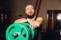 Athletic man puts on plate for barbell in the gym Royalty Free Stock Photo