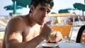 Young man by the sea at a beach bar