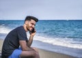 Young man by the sea talking on mobile phone Royalty Free Stock Photo