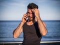 Young man by the sea talking on mobile phone