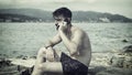 Young man by the sea talking on mobile phone Royalty Free Stock Photo