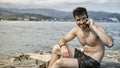 Young man by the sea talking on mobile phone Royalty Free Stock Photo