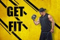 Athletic man in sleeveless hoody and baseball cap posing in half-turn and lifting dumbell in one hand agaisnt yellow