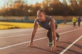 Athletic man standing in posture ready to run on a treadmill