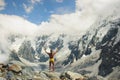 Athletic man stands at great height in front of the mountains