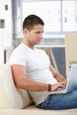 Athletic man using laptop at home