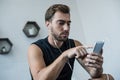 Young handsome man in tanktop and earbuds using