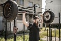 Athletic man working out with a dumbbell from tires. Strength and motivation. Outdoor workout Royalty Free Stock Photo