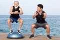 Athletic man making a step exercise with coach on balance platform