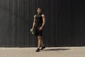 Athletic modern young man posing on a gray metallic wall copy sp