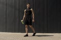 Athletic modern young man posing on a gray metallic wall copy space