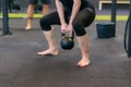 Athletic muscular woman lifting kettle weights