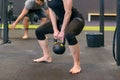 Athletic muscular woman lifting kettle weights