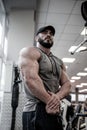 Athletic physique concept of strong young man with beard in sport gym