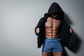 Athletic pumped male athlete in hoodie on gray background Royalty Free Stock Photo