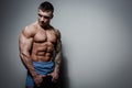 Athletic pumped man athlete bodybuilder with great muscled body on gray background Royalty Free Stock Photo