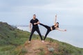 Athletic, pumped up, muscular, beautiful couple in love posing on the edge of the hill. Doing stretching and pair acro yoga on the Royalty Free Stock Photo