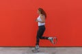 Athletic redhead woman running while wearing Kangoo Jumps boots
