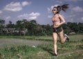 Athletic runner Asian woman training running series workout working hard outdoors on field background in harsh contrast light spor Royalty Free Stock Photo