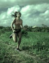 Athletic runner Asian woman training running series workout working hard outdoors on field background in harsh contrast light spor Royalty Free Stock Photo