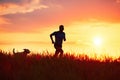 Athletic runner with dog at the sunset Royalty Free Stock Photo