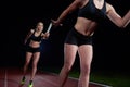 Athletic runners passing baton in relay race Royalty Free Stock Photo