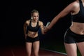 Athletic runners passing baton in relay race Royalty Free Stock Photo