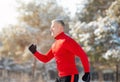 Athletic senior man in sportswear running at winter park, side view. Seasonal sports and tempering concept Royalty Free Stock Photo