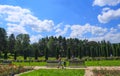 Athletic senior in sportswear wolk in a park and listening to music on headphones. Park, roses, green grass. Kislovodsk, Russia,