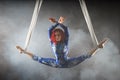 Athletic aerial circus artist with redhead in blue costume dancing in the air with balance Royalty Free Stock Photo