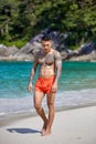 Athletic tattooed guy walking at the the tropical beach Royalty Free Stock Photo